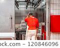 Butcher touching head entering cold storage room in slaughterhouse 120846096