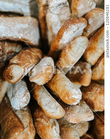 A close-up of freshly baked rustic baguettes with golden crust and a dusting of flour. 120846281