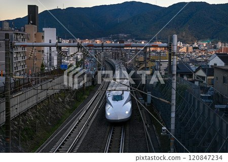 [京都]新幹線在傍晚的陽光下穿過城市 120847234