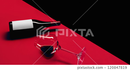 Mockup featuring a red wine bottle with blank label lying on diagonal red and black surface, accompanied by empty tilted wine glass. Presentation. 120847819