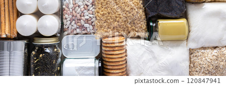 Home food supplies for quarantine and isolation, including canned food, cereals, pasta, and essential staples for survival, survival during military operations, the concept of stay at home, banner 120847941