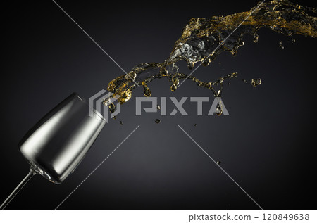 Glass and white wine splash on a black background. Glass and white wine splash on a black background. 120849638