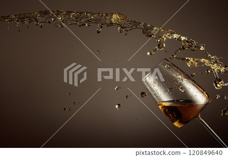 Glass and white wine splash on a beige background. Glass and white wine splash on a beige background. 120849640