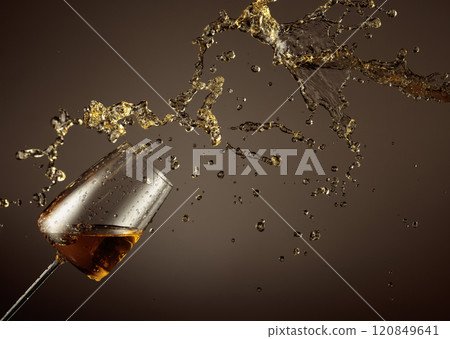 Glass and white wine splash on a beige background. Glass and white wine splash on a beige background. 120849641