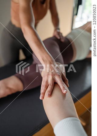 A detailed closeup of a foot work and core exercise on a Balanced Body Reformer machine illuminated by sunlight 120850023