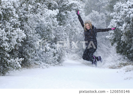 Young woman jumping in snow outdoor. Young woman jumping in snow outdoor. 120850146