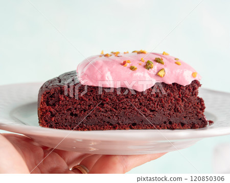 Piece of beetroot chocolate cake with pink cream cheese icing 120850306