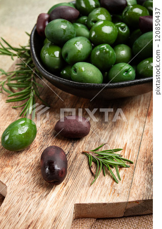 Chalkidiki olives, classic Greek green olives, in a bowl on a cutting board, top view, without people, Chalkidiki olives, classic Greek green olives, in a bowl on a cutting board, top view, without people, 120850437