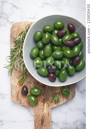 Chalkidiki olives, classic Greek green olives, in a bowl on a cutting board, top view, without people, 120850438