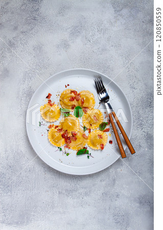 fresh ravioli, with butter, spices and herbs, fried bacon, on the table, top view, light background, no people, 120850559