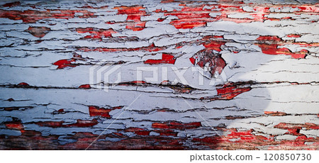 Detailed close-up of weathered wood showcasing peeling paint and vibrant colors in natural light 120850730
