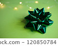 An Elegant Green Gift Bow beautifully placed on a Soft and Light Background that enhances its charm 120850784