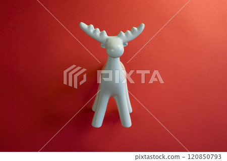 A Stylish White Moose Figurine Set Against a Bright Red Background to Enhance Its Appeal 120850793
