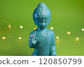 A Serene, Beautiful Buddha Statue on a Vibrant Green Background with Soft, Gentle Lights 120850799