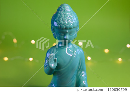 A Serene, Beautiful Buddha Statue on a Vibrant Green Background with Soft, Gentle Lights A Serene, Beautiful Buddha Statue on a Vibrant Green Background with Soft, Gentle Lights 120850799