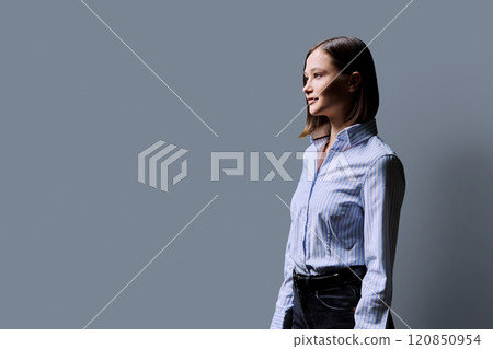 Profile portrait of young serious woman on grey background Profile portrait of young serious woman on grey background 120850954