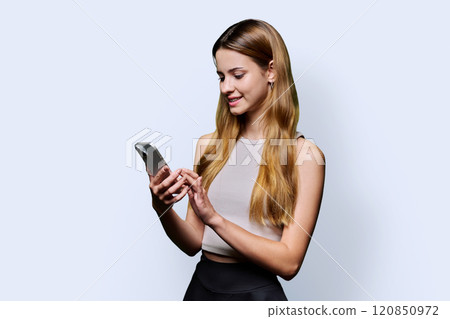 Young beautiful woman using smartphone on white studio background 120850972