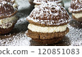 Sweet cream-filled cookies with powdered sugar served on a wooden table 120851083