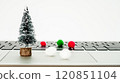 Miniature Christmas tree and colorful pom poms on a laptop during the holiday season 120851104