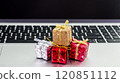 Small decorative gift boxes placed on a laptop keyboard during the holiday season 120851112