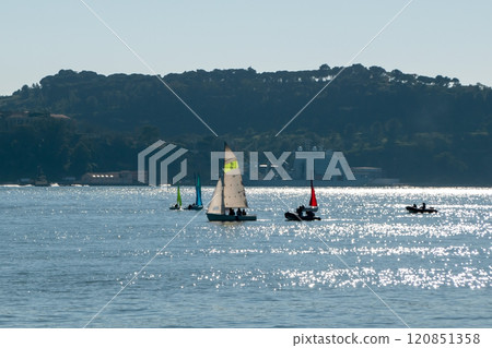 small boats with colorful sails, sailboats on the river at sunset small boats with colorful sails, sailboats on the river at sunset 120851358