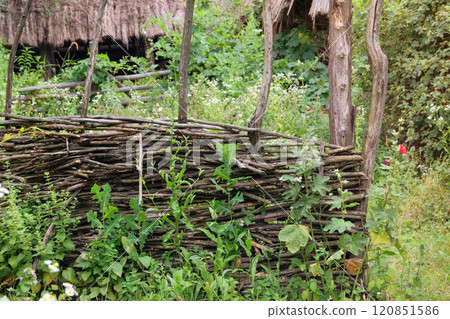 Aged wooden fence in countryside. Traditional wooden farmhouse. Village ethnographic museum. Vintage exterior. Sunny day. 120851586