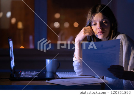Girl is working on a laptop at night at home. Girl is working on a laptop at night at home. 120851893