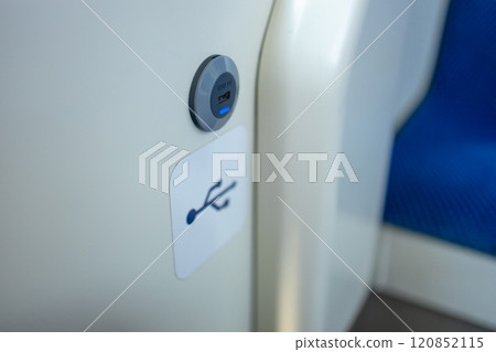 modern bus interior of passenger cabin with gadget USB charging port on handrail. Inside of city coach details. Mobile device charging station in public transport. Closeup view of power inlet 120852115