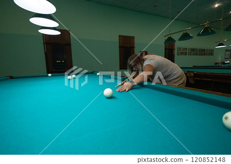 A woman likes to play billiards in her free time. A real person in casual clothes plays billiards with a group of his friends. People play billiards in a gaming pub. A woman likes to play billiards in her free time. A real person in casual clothes plays billiards with a group of his friends. People play billiards in a gaming pub. 120852148