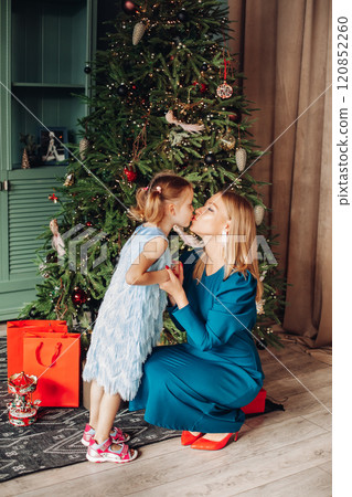 Little girl and her mom on Christmas morning at 120852260