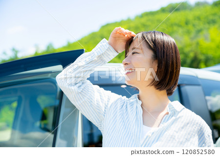 A woman on a road trip in a car Car and woman A woman on a road trip in a car Car and woman 120852580