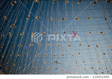Bright decorations hanging under a clear blue sky at a festive outdoor gathering in the evening 120852840