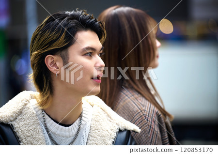 A young couple operating a smartphone in the streets of Shibuya 120853170