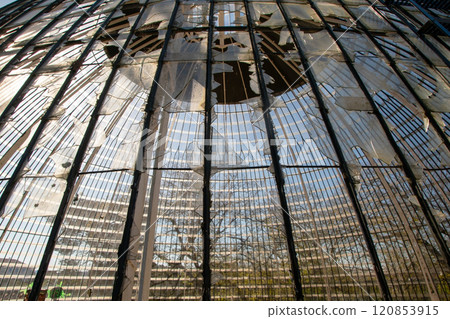Broken glass roof dome of greenhouse consisting of rectangular panels in the park of Lisbon, Portugal Broken glass roof dome of greenhouse consisting of rectangular panels in the park of Lisbon, Portugal 120853915
