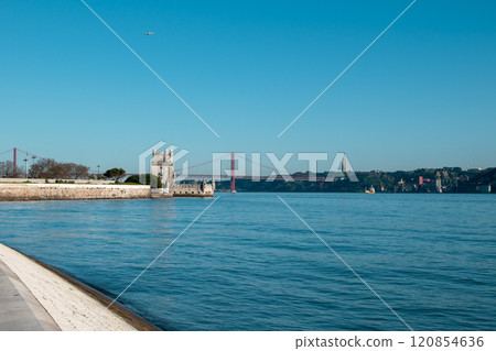 View of Tower of Belem and Ponte 25 de Abril Bridge at sunset, Lisbon, Portugal on the Tagus River View of Tower of Belem and Ponte 25 de Abril Bridge at sunset, Lisbon, Portugal on the Tagus River 120854636