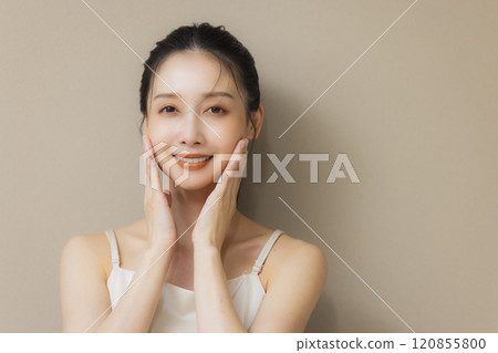 Woman smiling with hands on face 120855800