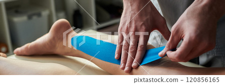 Applying Therapeutic Kinesiology Tape on Leg 120856165