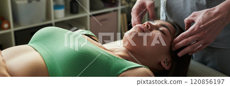 Receiving Relaxing Facial Massage in Spa Setting 120856197