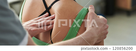 Adjusting Patient's Shoulder for Physical Therapy Session 120856200
