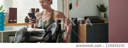 Watching Smartphone While Sitting in Workout Room 120856242