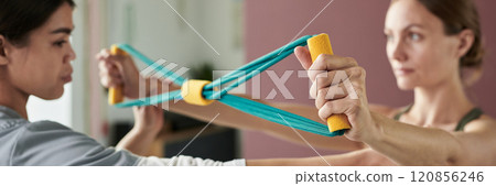 Engaging in a Therapeutic Elastic Band Exercise Session Engaging in a Therapeutic Elastic Band Exercise Session 120856246