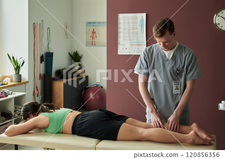 Professional Massage Therapist Treating Female Patient 120856356