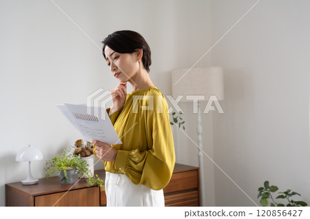 一名婦女拿著文件站在室內 120856427