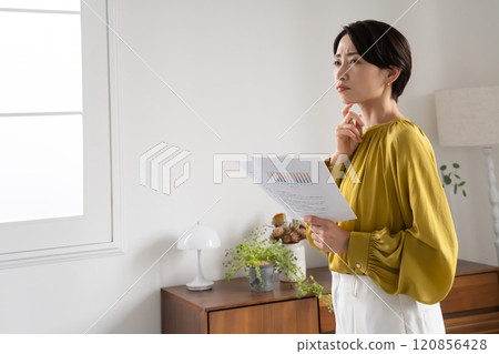 一名婦女拿著文件站在室內 120856428