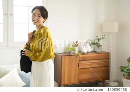 一名女子背著單肩包站在室內 120856468