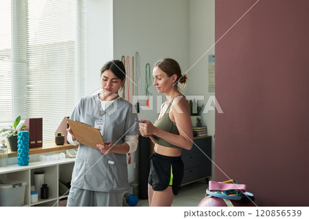 Discussing Fitness Plan During Personal Training Session 120856539
