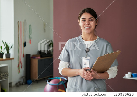 Portrait of Female Nurse Smiling and Holding Clipboard 120856626