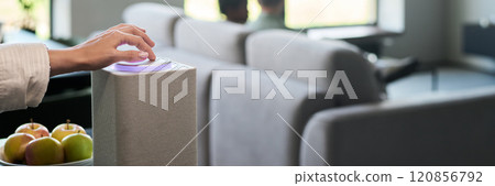 Adjusting Smart Speaker in Modern Living Room 120856792