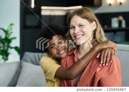 Smiling Woman Hugged by Child with Bright Expression Smiling Woman Hugged by Child with Bright Expression 120856867