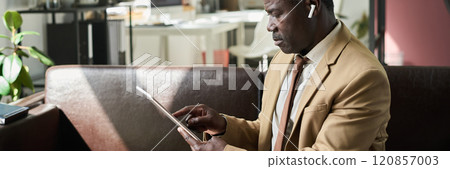 Mature man pointing at tablet screen Mature man pointing at tablet screen 120857003